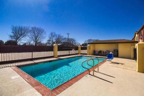 a swimming pool in a yard with a fence at Quality Inn Bay City TX in Bay City