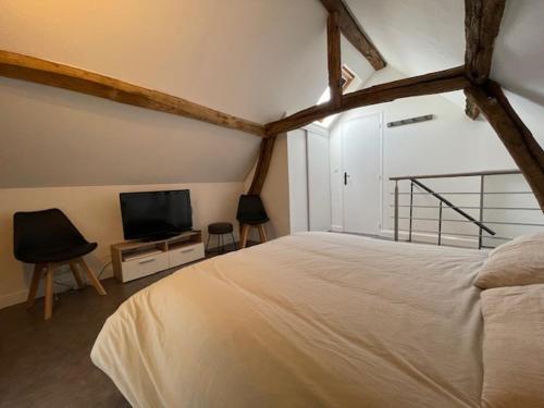 a bedroom with a bed and a flat screen tv at Cosy sur Ourcq 