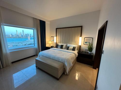 Cette chambre comprend un lit et une grande fenêtre. dans l'établissement Fairmont Marina Abu Dhabi, à Abu Dhabi