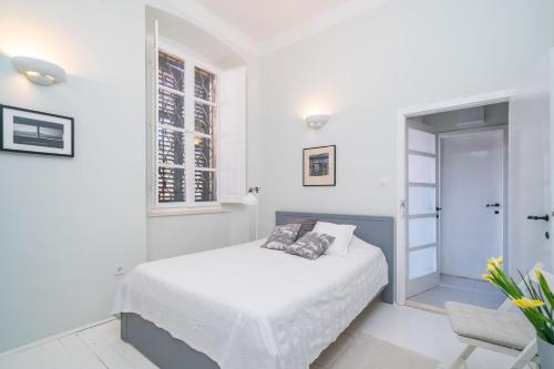 Habitación blanca con cama y ventana en Apartment Ranieri Pile, en Dubrovnik