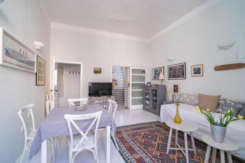 una sala de estar blanca con mesa y sillas en Apartment Ranieri Pile en Dubrovnik
