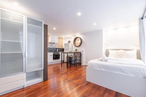 une chambre blanche avec un lit et une cuisine dans l'établissement Old Lille - studio ideally located !, à Lille