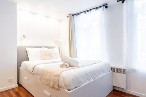 Dormitorio blanco con cama y ventana en Old Lille - studio ideally located !, en Lille