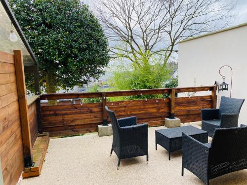 eine Terrasse mit Stühlen, einem Tisch und einem Zaun in der Unterkunft Studio au calme avec terrasse - hauteurs de Rouen in Bihorel