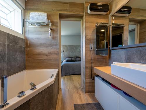 une salle de bain avec une baignoire et un lavabo dans l'établissement Villa Agua - Villa piscine privée, vue sur le lagon, à Mèze