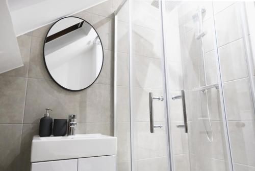 a white bathroom with a mirror and a sink at Stylish Studio Apartments, Willesden in London