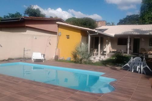 a house with a swimming pool in the yard at Casa de campo agradável com piscina aquecida in Juatuba