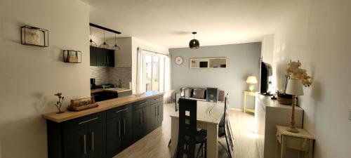 a kitchen with black cabinets and a counter top at Appart T3 a 50 m de la plage in Cavalaire-sur-Mer