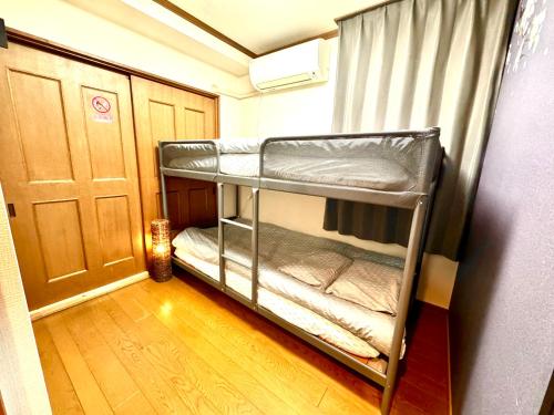 a bunk bed room with two bunk beds in it at 3 Best location small private room!cozy place in JUJO shopping street in Tokyo