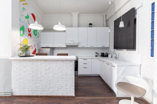 uma cozinha branca com armários brancos e um balcão em #Alice by halu! Apartments em Tessalônica