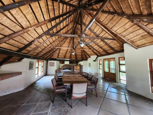 a large room with a wooden ceiling with a table and chairs at Lama Lama Game Reserve in Mount Hope