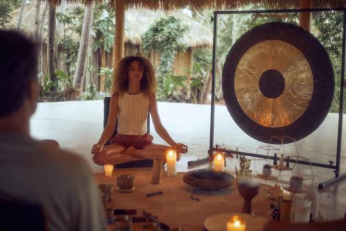 a woman sitting in a meditation room with candles at Cayo Levantado Resort - All Inclusive in Santa Bárbara de Samaná