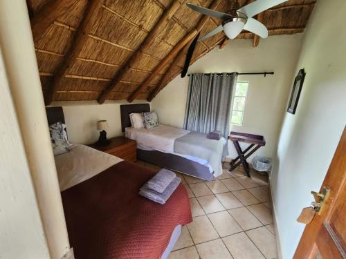 a bedroom with two beds and a ceiling at Lama Lama Game Reserve in Mount Hope