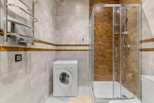 y baño con lavadora y ducha. en Sea Symphony Luxury Apartments, en Odessa