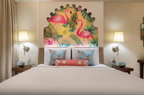 a bedroom with a bed with a painting of flamingos at Taj Gorbandh Palace, Jaisalmer in Jaisalmer