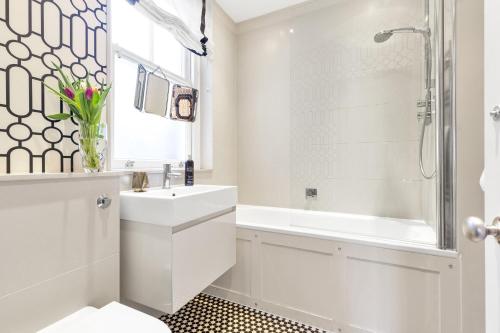 a white bathroom with a sink and a shower at London Chelsea in London