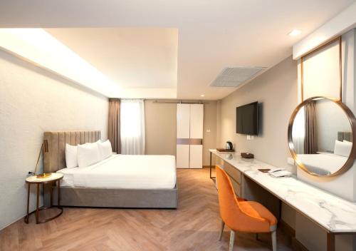 ein Hotelzimmer mit einem Bett und einem Spiegel in der Unterkunft Away Bangkok Riverside Kene in Bangkok
