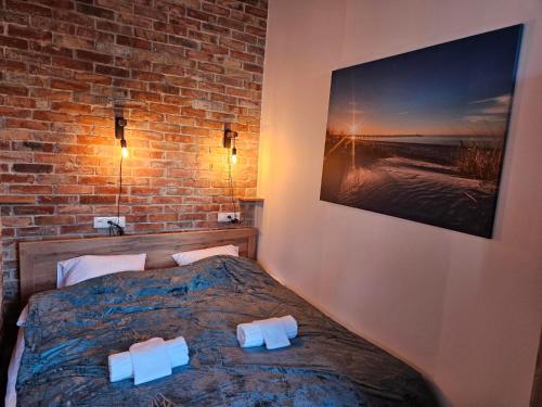 a bedroom with a bed and a brick wall at Main Street Apartments in Sopot