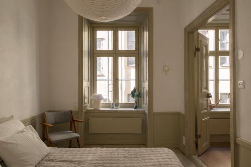 een slaapkamer met een bed, een raam en een stoel bij The architects' house in Stockholm
