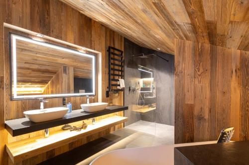 a bathroom with two sinks and a mirror at Hotel Meta Resort & Vine SPA in Szczyrk