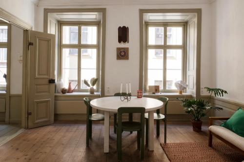 uma sala de estar com uma mesa, cadeiras e janelas em The architects' house em Estocolmo