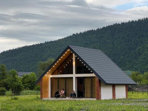 博爾若米的住宿－Borjomi inn Cottages，一个小房子,里面的人坐在窗户里