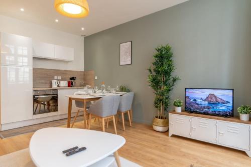 een keuken en eetkamer met een tafel en een tv bij Lille Centre - Nice and functional ap. in Lille