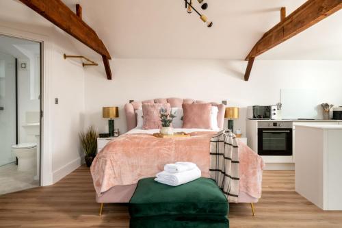 a bedroom with a pink bed and a green ottoman at Stargaze in Blandford Forum