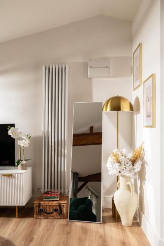 a living room with a mirror and a vase with flowers at Stargaze in Blandford Forum