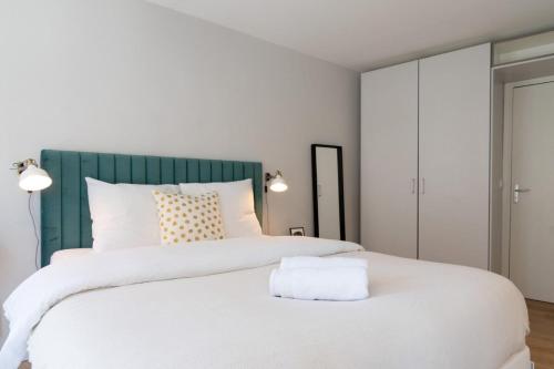 - une chambre avec un grand lit blanc et une tête de lit verte dans l'établissement Lille Hypercentre/Train station-Superb studio, à Lille