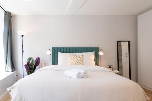 - une chambre avec un lit blanc et une tête de lit verte dans l'établissement Lille Hypercentre/Train station-Superb studio, à Lille