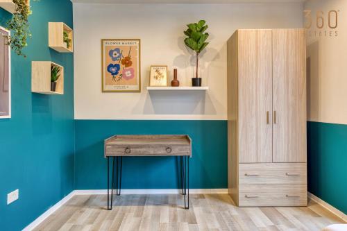 a room with a desk and a cabinet at Modern Paceville Suites with WIFI & AC by 360 Estates in Paceville