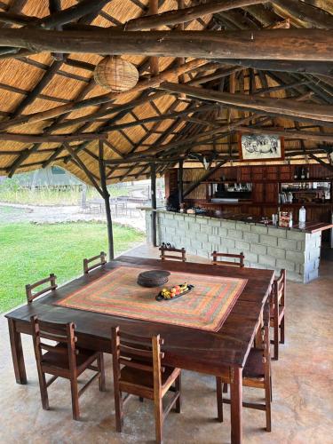 una gran mesa de madera con sillas en un edificio en Sukulu Reserve en Livingstone