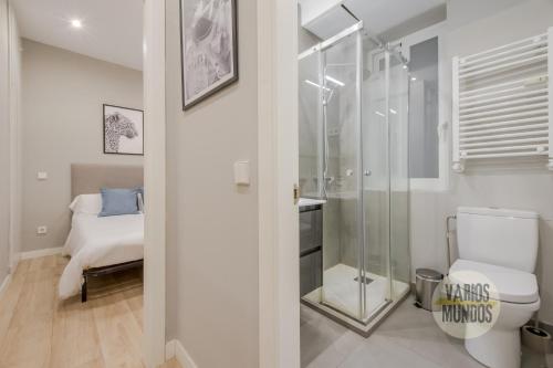 uma casa de banho com um chuveiro, um WC e uma cama em Acogedor Apt 3 habitaciones y terraza en el Centro de Madrid em Madrid