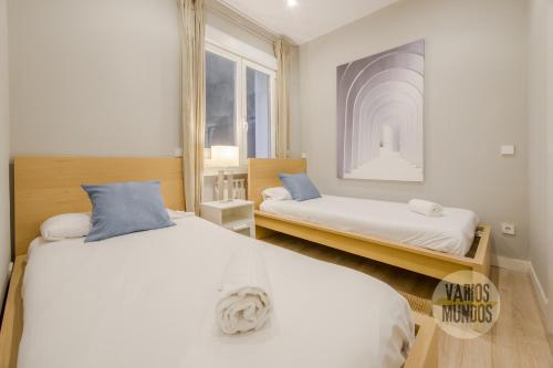 um quarto com 2 camas e uma janela em Acogedor Apt 3 habitaciones y terraza en el Centro de Madrid em Madrid