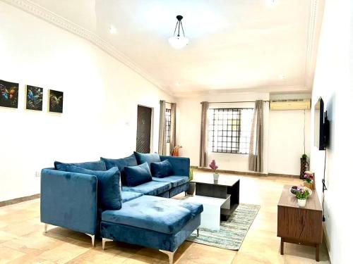 a living room with a blue couch and a table at Wyndham Villa in Ogbojo
