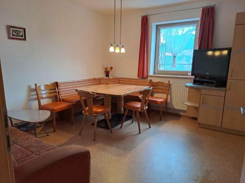 ein Esszimmer mit einem Tisch, Stühlen und einem TV in der Unterkunft Apartment in Fügenberg/Zillertal 727 in Pankrazberg