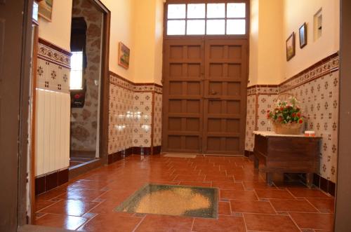 a hallway with a door and a tile floor at La Antigua, casa céntrica, amplio patio y barbacoa in Campillo de Altobuey