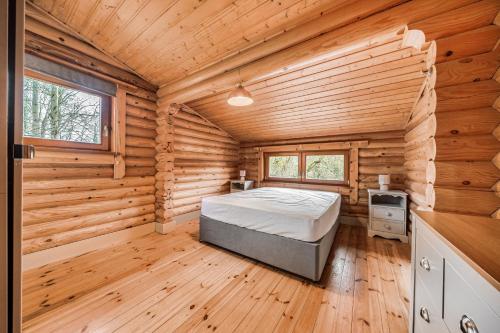 a bedroom with a bed in a log cabin at Kingfisher Lodge and mooring on the River Ouse in Renhold