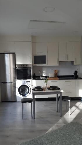 a white kitchen with a table and a refrigerator at Apartamentos SARABIA LOFT in Ourense