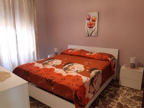 ein kleines Schlafzimmer mit einem Bett mit Avertisementatron in der Unterkunft Tindara's House in Francavilla di Sicilia