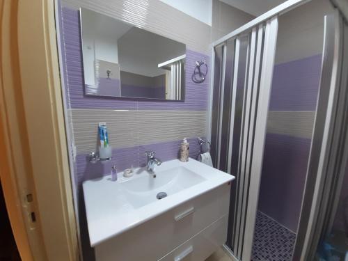 a bathroom with a white sink and a mirror at Tindara's House in Francavilla di Sicilia