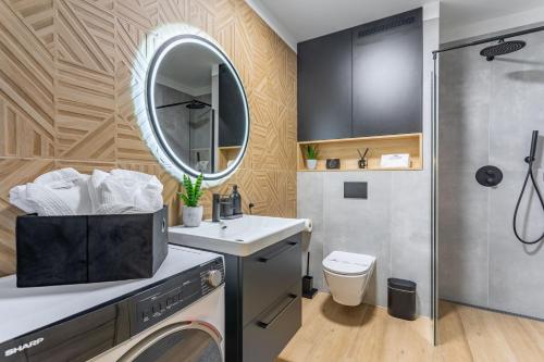 y baño con lavadora, lavabo y espejo. en Green Park Resort Apartament B29 Baseny, Sauny, Siłownia en Szklarska Poręba