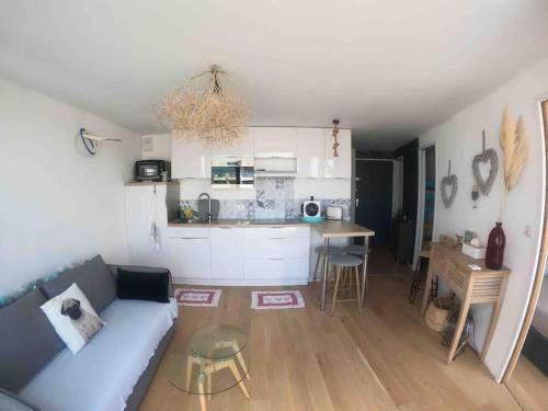 un salon avec un canapé et une cuisine dans l'établissement Appart 4 pers piscine Couchant, à La Grande Motte