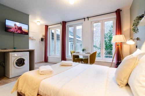 une chambre avec un grand lit blanc et des fenêtres dans l'établissement Hypercentre-gares: superbe studio équipé, à Lille