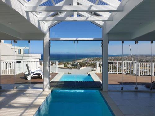 a view from the balcony of a house with a swimming pool at 'The Bolussi Beachhouse', sleeps 12 in 6 en-suite bedrooms with Indoor Pool in Gordonʼs Bay