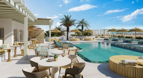 カラファティスにあるNUMO Mykonos Boutique Resortのリゾートで、プール、テーブル、椅子を提供しています。