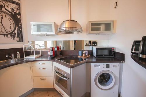 une cuisine avec un évier et une machine à laver dans l'établissement Beautiful apartment on the Grand Place !, à Lille
