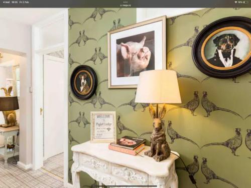 a room with green walls and a table with a lamp at Piglet Lodge in Pebworth