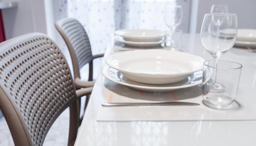 a table with plates and wine glasses on it at Italianway Comfort - Merlo 1 D in Milan